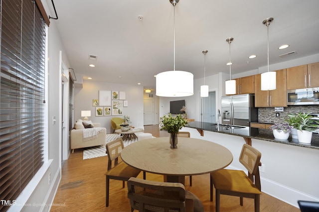dining area with light wood finished floors, visible vents, and recessed lighting