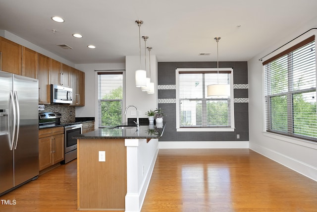 kitchen featuring baseboards, a sink, visible vents, and stainless steel appliances