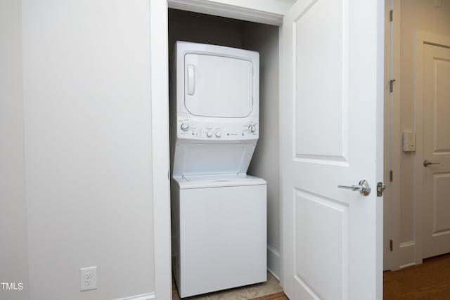 clothes washing area with laundry area and stacked washer and dryer