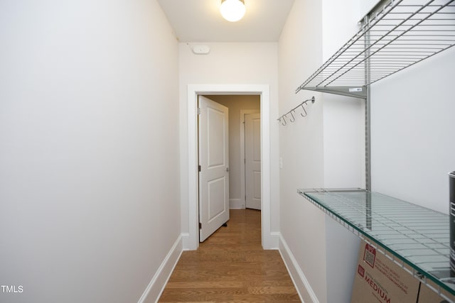 hall featuring light wood-type flooring and baseboards