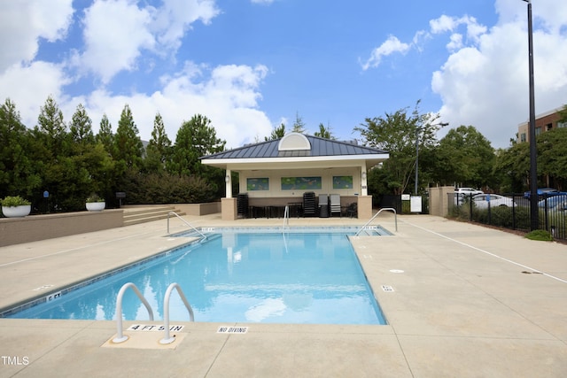pool with a patio and fence