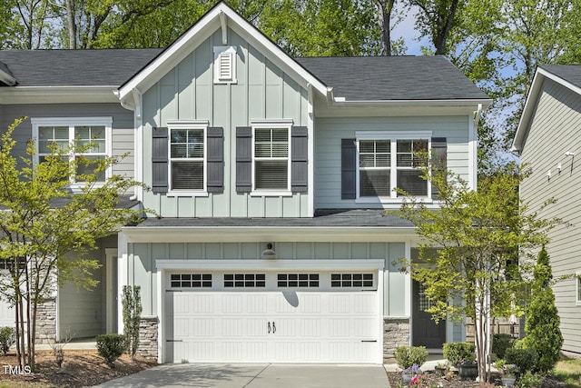 craftsman inspired home with driveway, board and batten siding, a garage, and stone siding