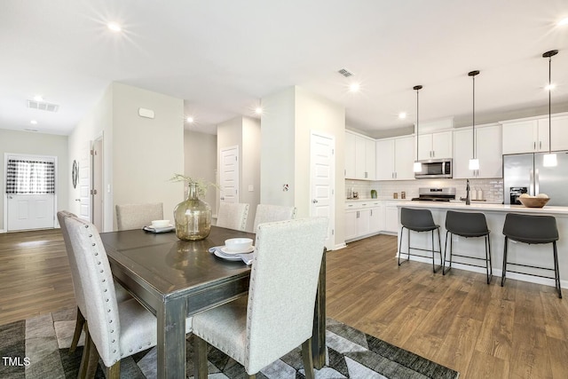 dining room with recessed lighting, visible vents, and dark wood-style flooring