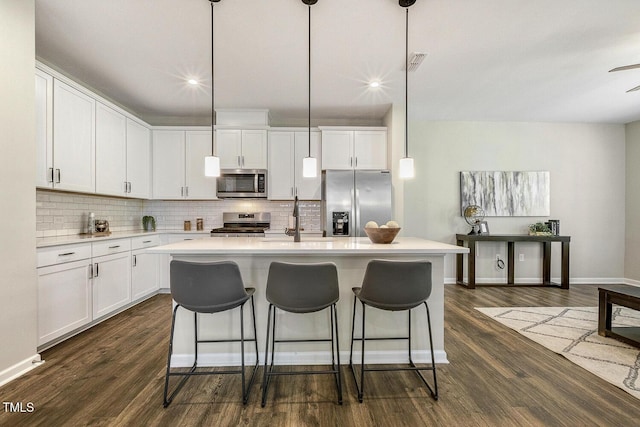 kitchen with a sink, backsplash, light countertops, and appliances with stainless steel finishes