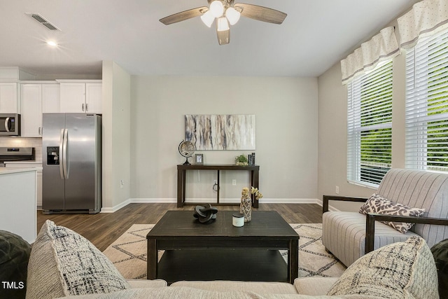 living area featuring dark wood-style floors, baseboards, a ceiling fan, and visible vents