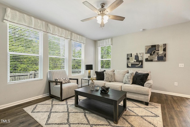 living area featuring baseboards, a ceiling fan, and wood finished floors