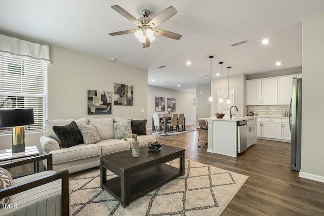 living area featuring ceiling fan, visible vents, recessed lighting, baseboards, and dark wood-style floors