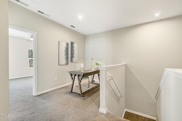 corridor with visible vents, baseboards, and an upstairs landing