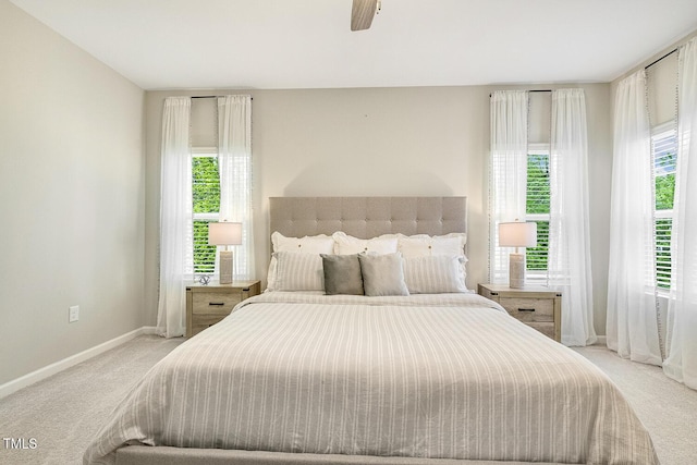 bedroom featuring light carpet, baseboards, and multiple windows