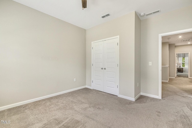 unfurnished bedroom with a closet, carpet flooring, visible vents, and baseboards