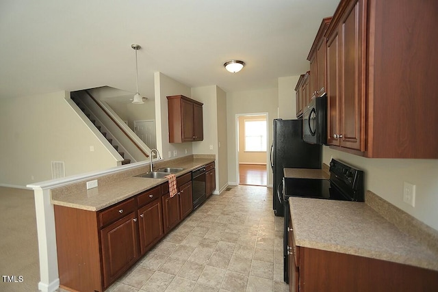 kitchen featuring baseboards, a peninsula, light countertops, black appliances, and a sink