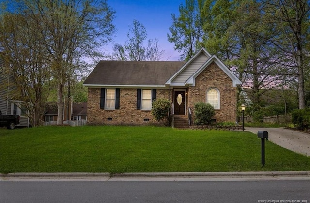 ranch-style home featuring crawl space, concrete driveway, a front lawn, and brick siding