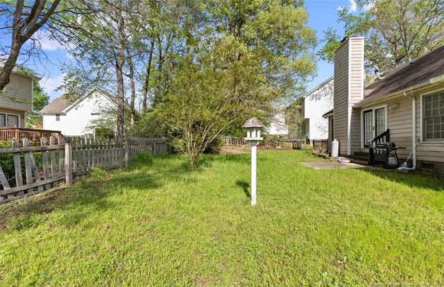 view of yard with entry steps and a fenced backyard
