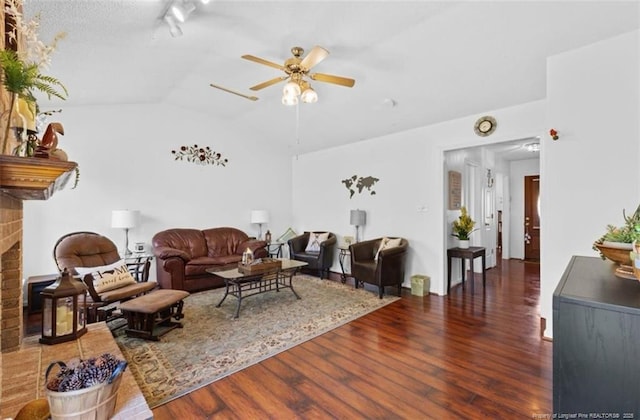 living area with a fireplace, lofted ceiling, ceiling fan, and wood finished floors