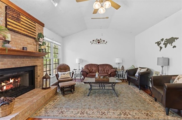 living area featuring a fireplace, vaulted ceiling, a ceiling fan, and wood finished floors