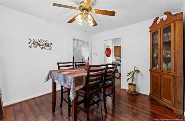 dining space featuring dark wood-style floors, baseboards, and a ceiling fan