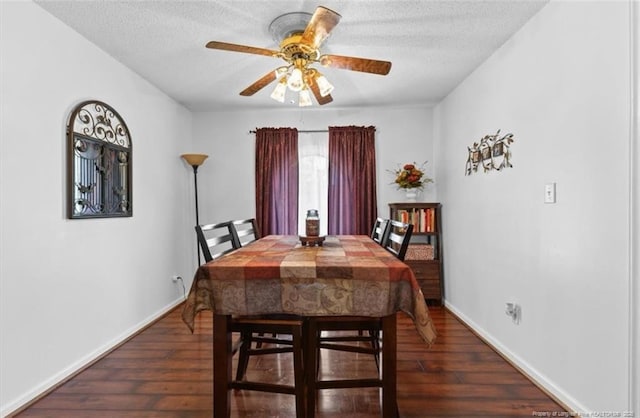 dining space with a textured ceiling, wood finished floors, ceiling fan, and baseboards