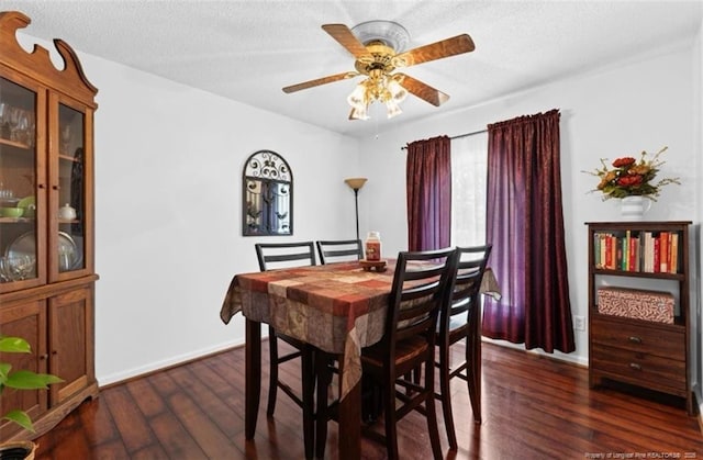 dining room with a textured ceiling, ceiling fan, and dark wood-style floors