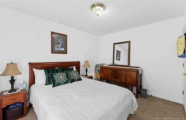 carpeted bedroom with a textured ceiling and baseboards
