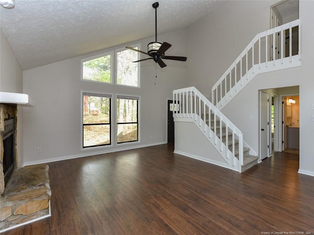 494 Wilder Dr, Fayetteville, NC 28314 - unfurnished living room featuring a stone fireplace, ceiling fan, stairway, wood finished floors, and high vaulted ceiling