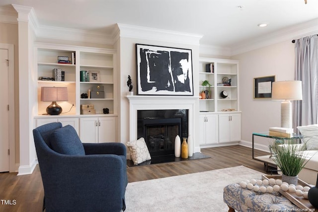 living room featuring crown molding, baseboards, wood finished floors, and a fireplace