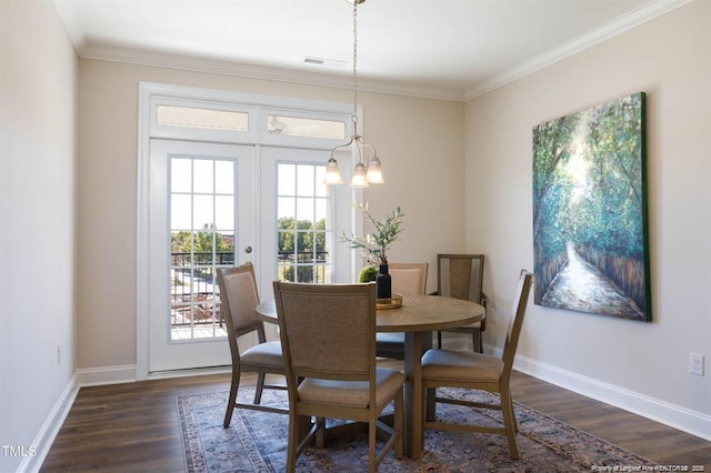 dining area featuring baseboards, ornamental molding, a chandelier, dark wood-type flooring, and french doors