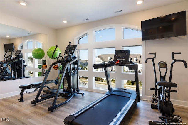 exercise area with wood finished floors, recessed lighting, visible vents, and a wealth of natural light