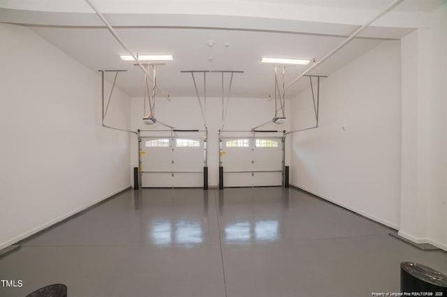 garage featuring a garage door opener and baseboards