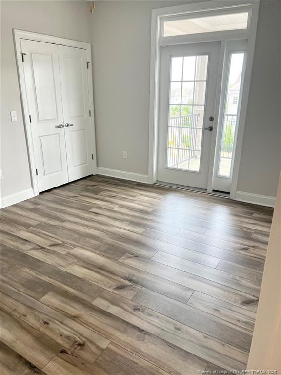 interior space with baseboards and wood finished floors