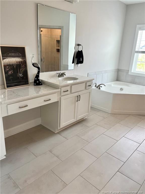 full bathroom with tile patterned floors, a garden tub, and vanity