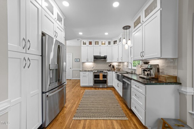 2520 Ashley Ct, Raleigh, NC 27607 - kitchen with white cabinetry, backsplash, light wood-style floors, appliances with stainless steel finishes, and a sink