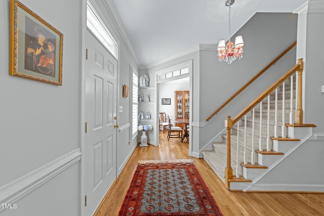 2520 Ashley Ct, Raleigh, NC 27607 - entryway featuring crown molding, wood finished floors, stairs, a notable chandelier, and baseboards