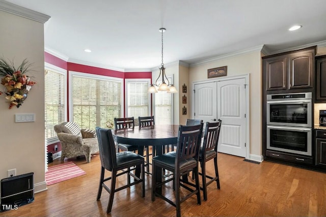 12808 Edsel Dr, Raleigh, NC 27613 - dining space featuring crown molding, wood finished floors, an inviting chandelier, and baseboards