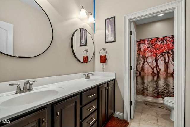 12808 Edsel Dr, Raleigh, NC 27613 - bathroom featuring toilet, tile patterned floors, double vanity, and a sink