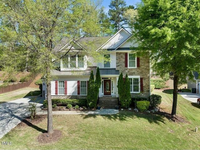 12808 Edsel Dr, Raleigh, NC 27613 - view of front facade with driveway, stone siding, fence, and a front lawn