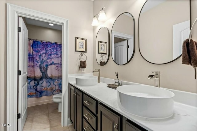 12808 Edsel Dr, Raleigh, NC 27613 - full bathroom featuring a sink, toilet, double vanity, and tile patterned flooring