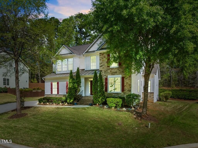 12808 Edsel Dr, Raleigh, NC 27613 - view of front facade featuring stone siding, a front yard, a standing seam roof, metal roof, and a shingled roof