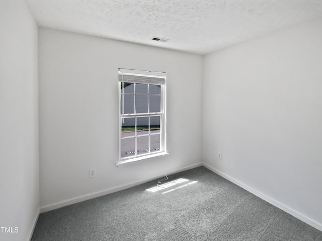 carpeted spare room with visible vents and baseboards