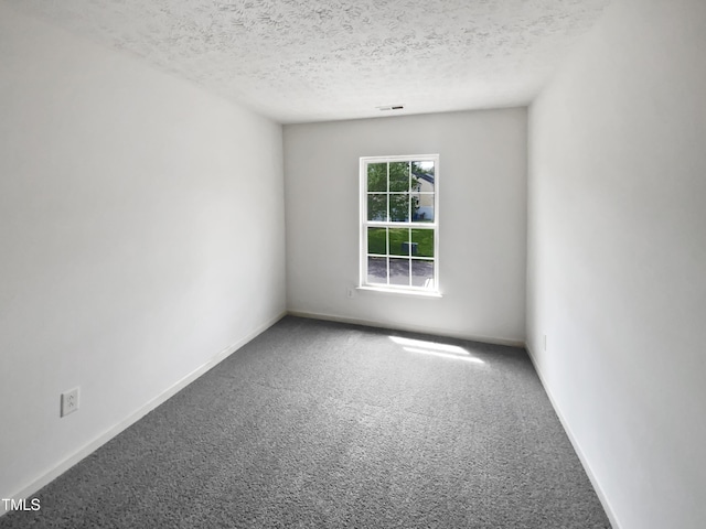 carpeted empty room with visible vents, a textured ceiling, and baseboards