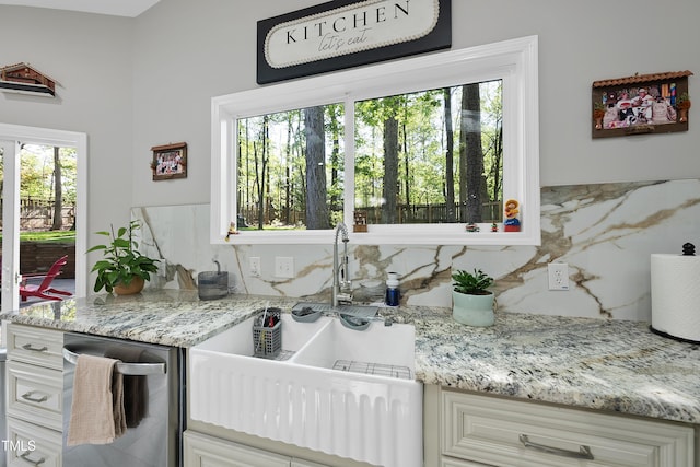 interior space featuring a sink, backsplash, and light stone countertops