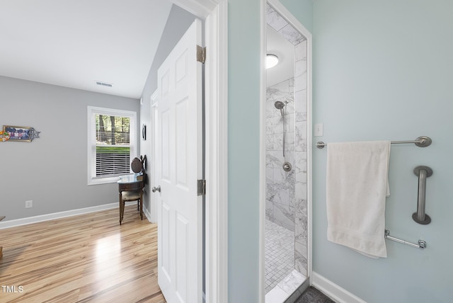 bathroom with a shower stall, visible vents, baseboards, and wood finished floors