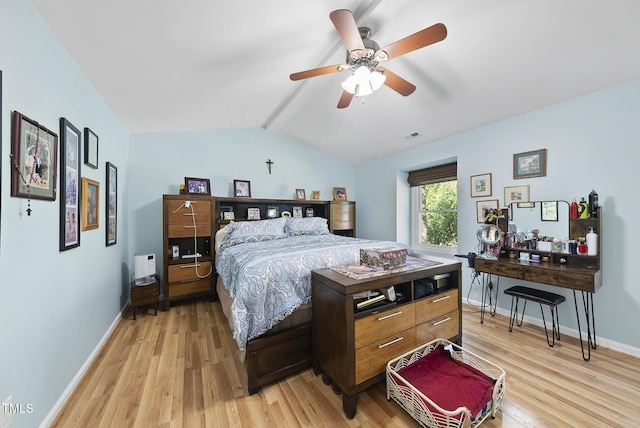 bedroom with light wood-style flooring, ceiling fan, baseboards, and vaulted ceiling with beams
