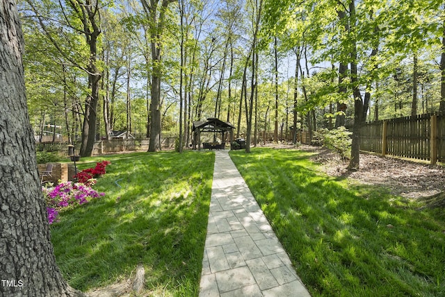 view of property's community with a yard, a gazebo, and fence