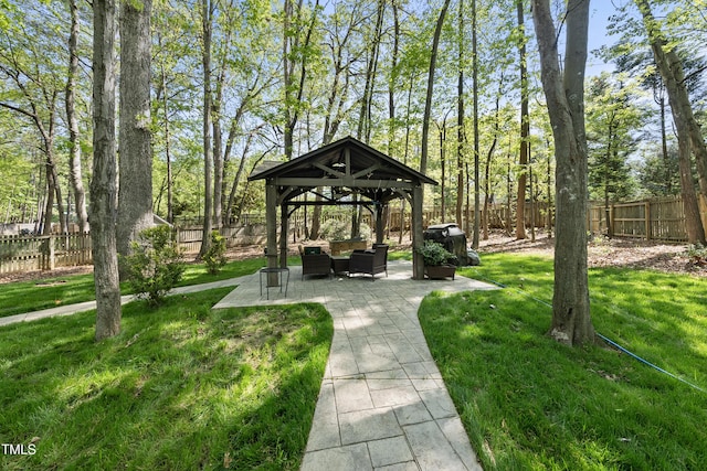 view of property's community featuring a yard, a fenced backyard, a gazebo, and a patio area