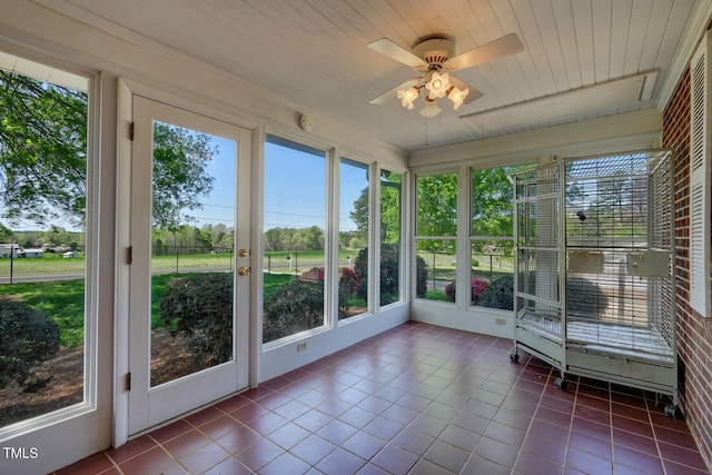 unfurnished sunroom with ceiling fan and a wealth of natural light
