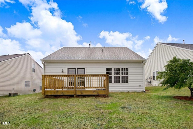 rear view of house with roof with shingles, central AC unit, a wooden deck, and a lawn