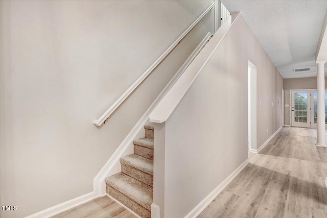 stairs with visible vents, baseboards, ornate columns, and wood finished floors