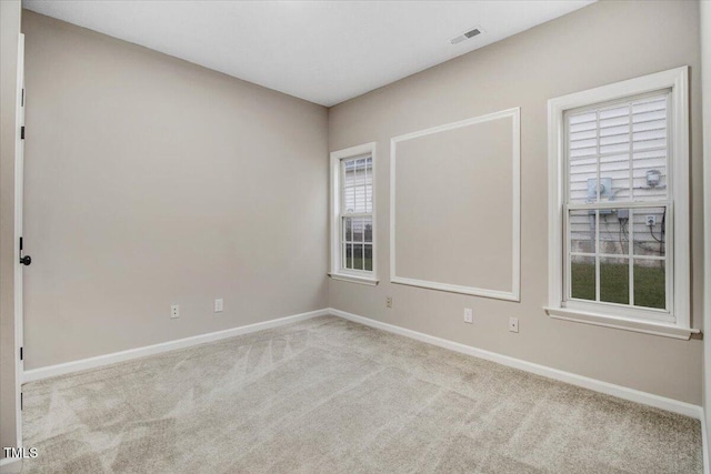 empty room featuring carpet floors, baseboards, and visible vents