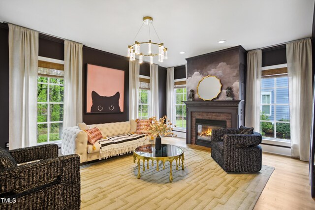 3332 Cheswick Dr, Raleigh, NC 27609 - living area featuring a glass covered fireplace, recessed lighting, an inviting chandelier, and wood finished floors