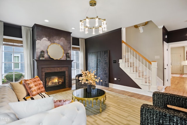 3332 Cheswick Dr, Raleigh, NC 27609 - living area featuring ornamental molding, a chandelier, stairs, a brick fireplace, and wood finished floors